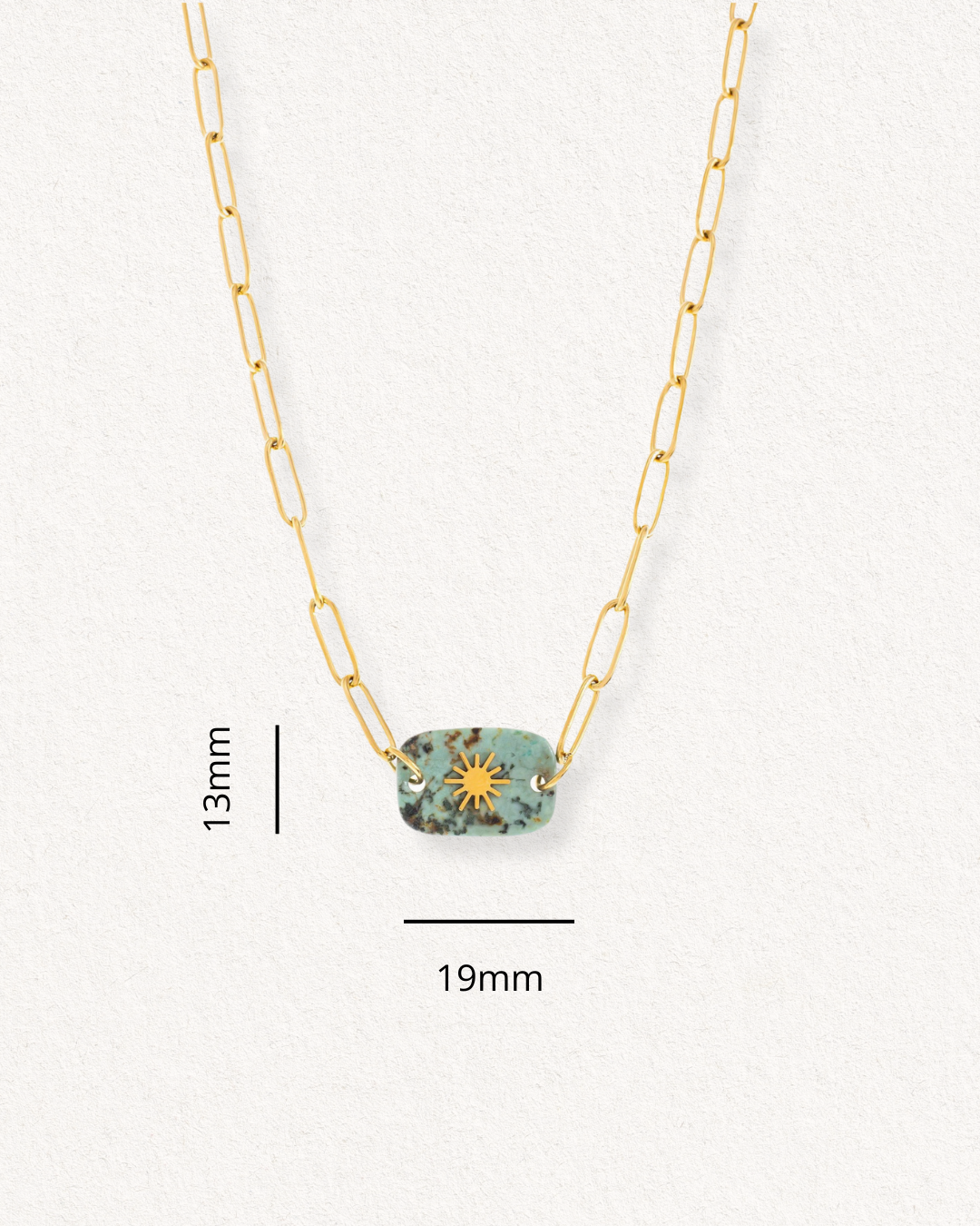 Atklājiet Kaklarota - Saules akmens ceļš no Como Jewelry: zelta ķēdīte ar 13x19 mm taisnstūra formas tirkīza piekariņu ar saules plankumainu rakstu. Izgatavots no antialerģiska materiāla, attēlots uz teksturēta fona.