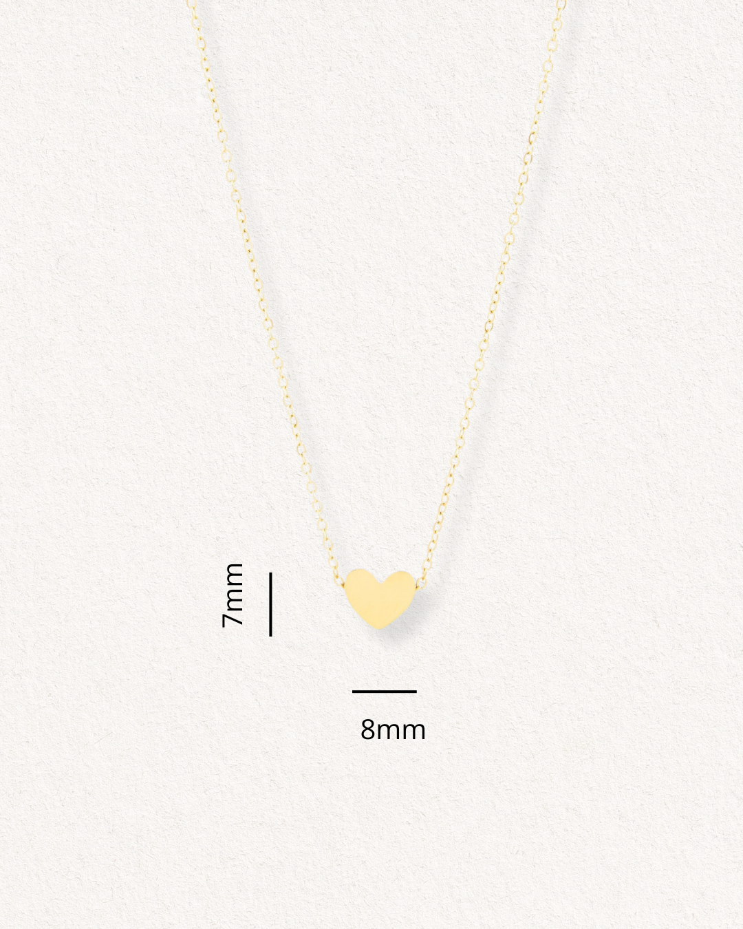 Como Jewelry Kaklarota - Sirds: zelta kaklarota ar smalku ķēdīti un nelielu sirds formas piekariņu (7 mm x 8 mm), kas attēlots uz gaišas faktūras fona.
