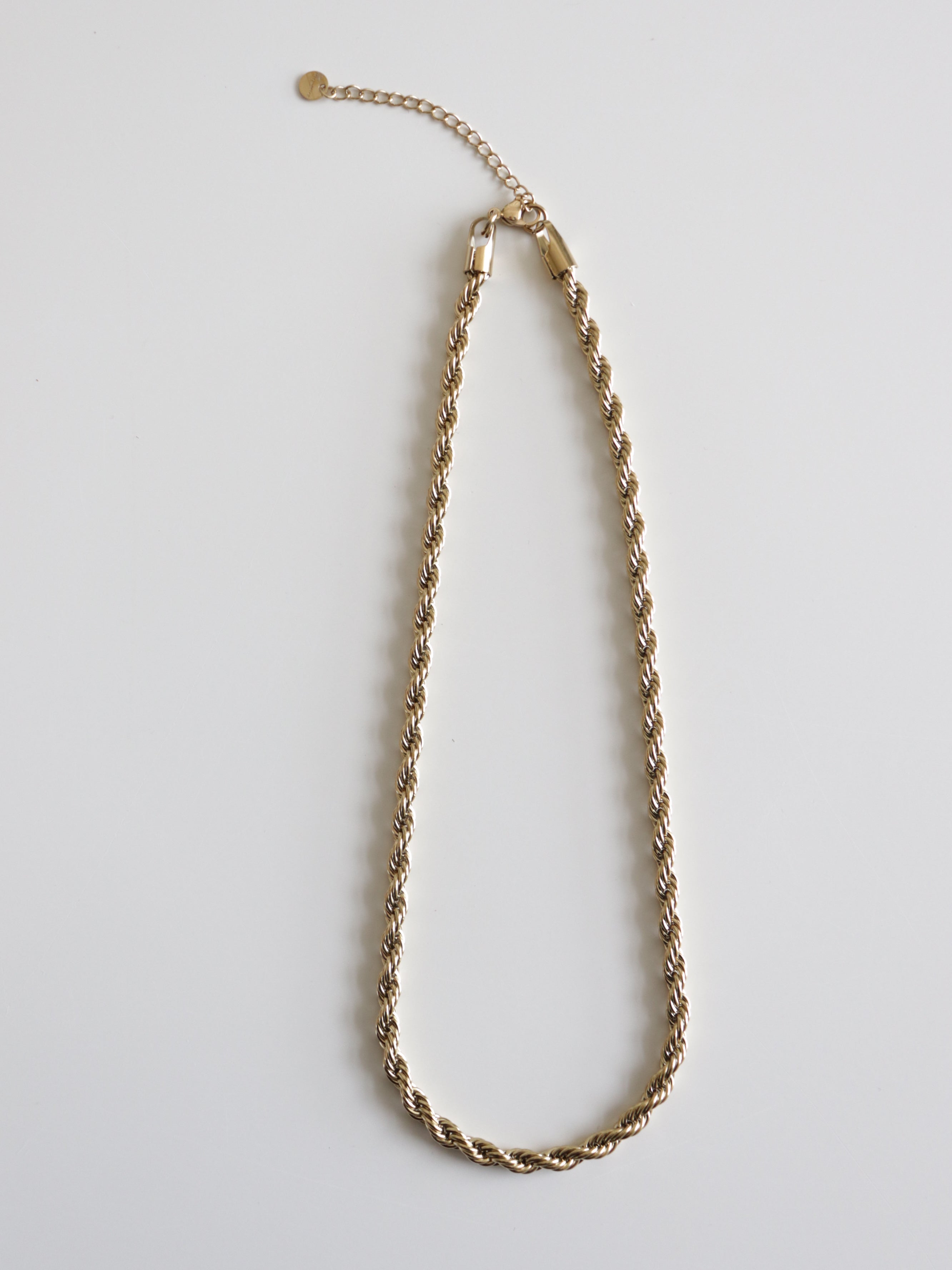 Como Jewelry "Kaklarota - Zelta ķēde" ar juveliertērauda pinumu, ērtu aizdari un regulējamu pagarinājumu uz balta fona. Antialerģiska rotaslieta elegantai sievietes ikdienai.