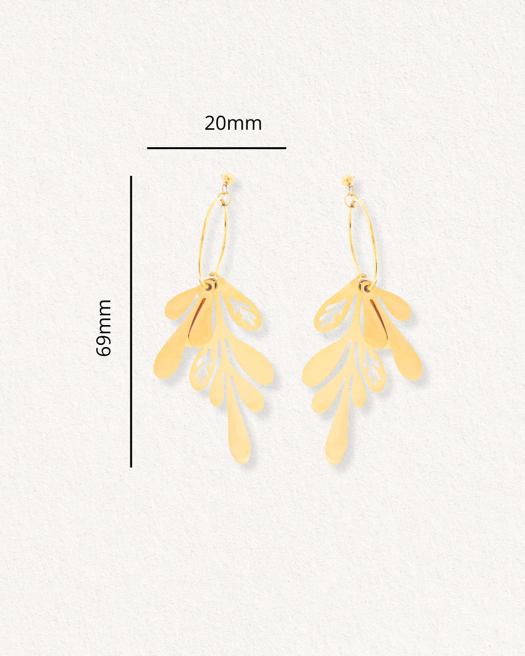 Auskari - Brīze by Como Jewelry ir zeltīti auskari ar lapām līdzīgu dizainu, kuru izmēri ir 69 mm x 20 mm un kuri izvietoti uz gaišas faktūras fona.