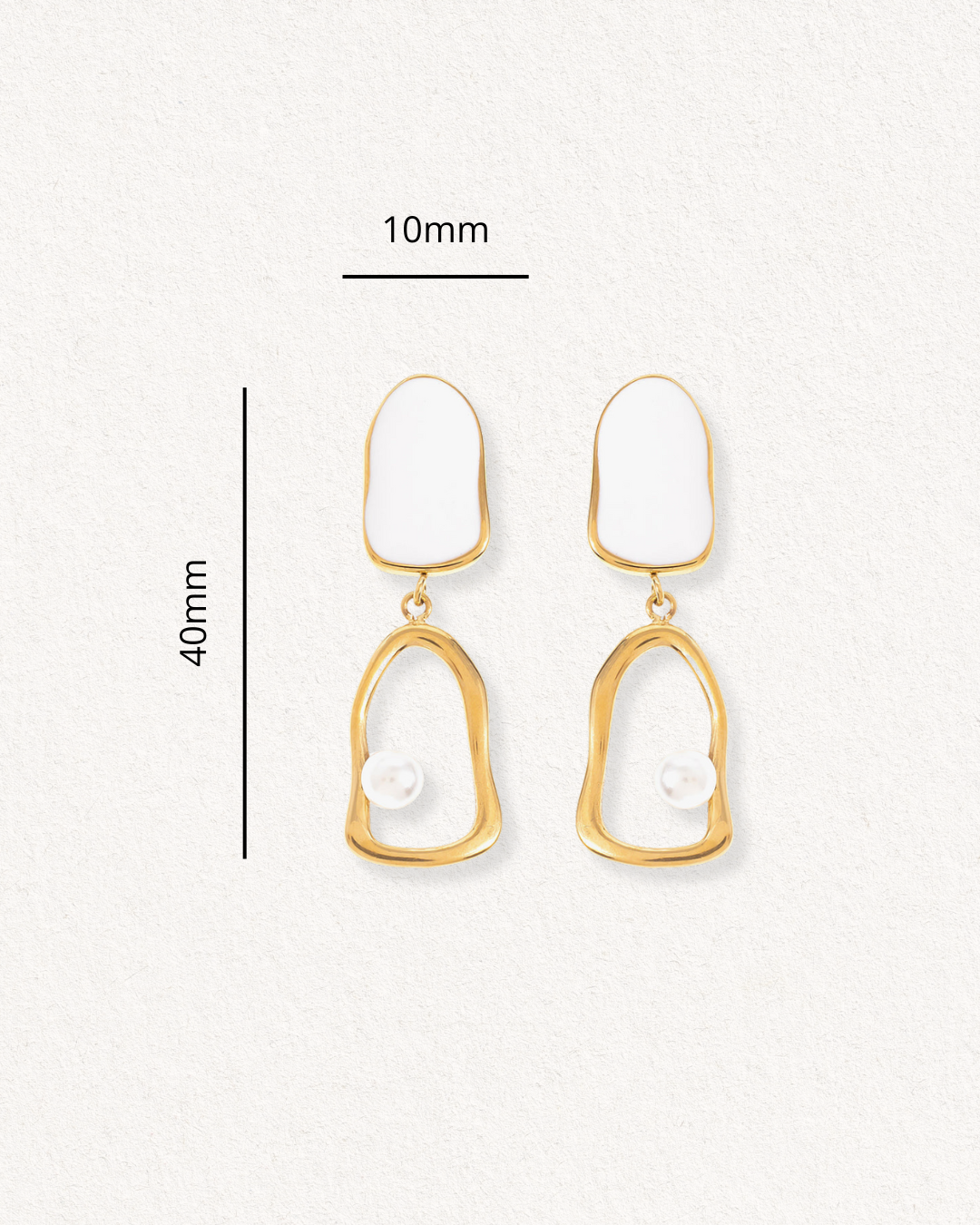 Auskari - Atspulgs by Como Jewelry: zelta krāsas, ūdensizturīgi auskari ar neregulāru ovālu formu, baltiem emaljas akcentiem un vienu pērli. Izmērs: 40 mm x 10 mm. Attēlots uz gaišas faktūras fona.