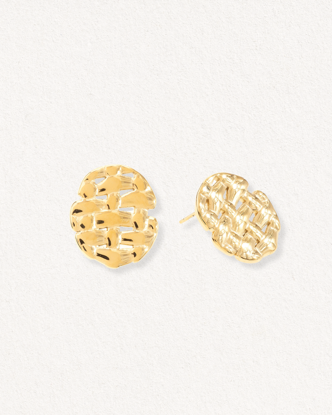 Mazie auskari - Pinums no Como Jewelry, ar apaļiem, teksturētiem zelta spraudņiem ar organisku austu dizainu uz gaiši baltas krāsas fona.