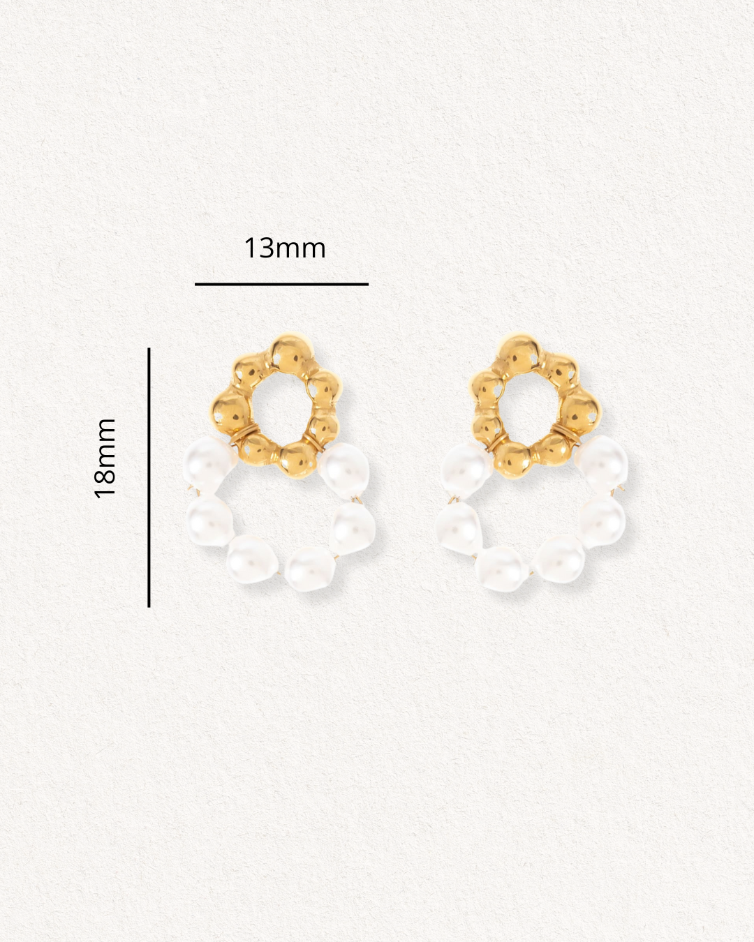 Mazie auskari - Pērļu ziediņi by Como Jewelry: apzeltīti nerūsējošā tērauda auskari ar apaļu zelta virsmu un baltām pērlēm, izmērs 18 mm x 13 mm, attēlots uz fakturēta gaiša fona.