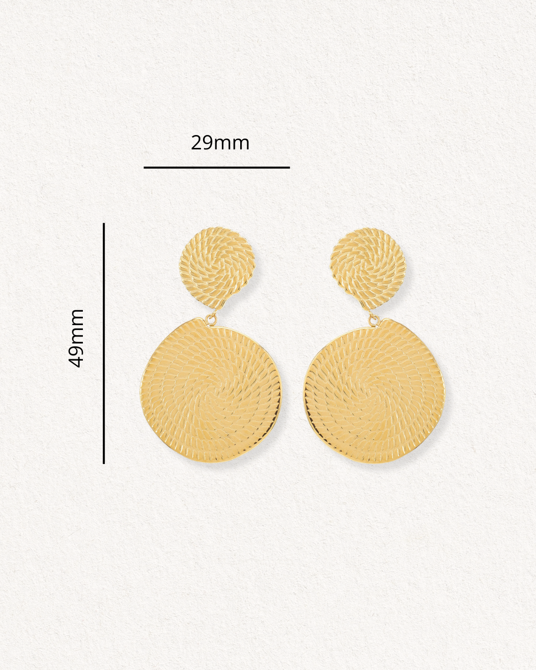 Auskari - Grācija: zelta pārklājuma juveliertērauda sieviešu auskari ar spirālveida tekstūru, apaļu augšdaļu un lielāku apaļu piekariņu, izmērs 49x29mm, uz viegli teksturēta fona.