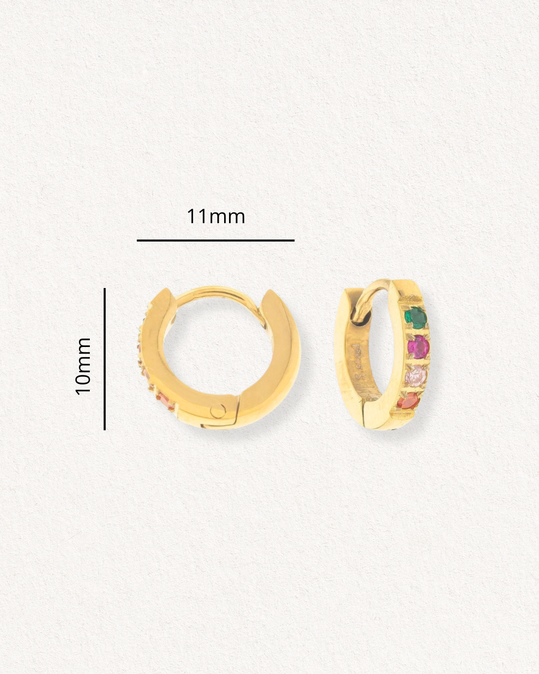 Mazie auskari - Krāsainie kristāli no Como Jewelry: tērauda pāris ar zelta pārklājumu, 11mm plati un 10mm augsti, rotāti daudzkrāsainiem akmentiņiem vienā pusē, attēloti uz gaiša teksturēta fona.