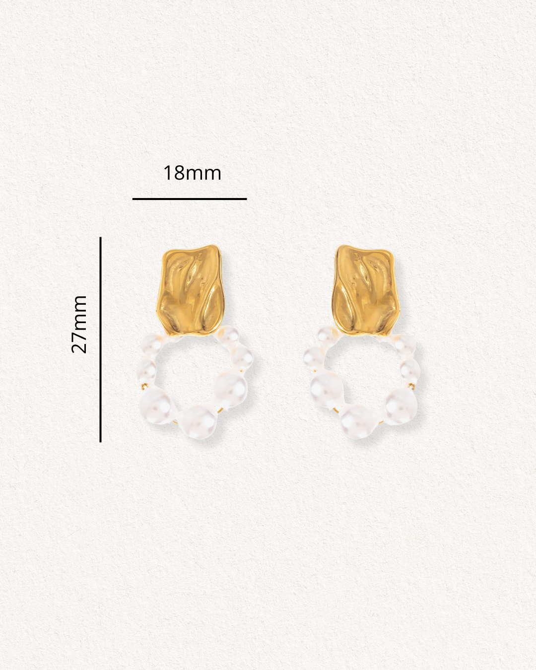 Como Jewelry Mazie auskari - Pērļu loks: eleganti zeltīti auskari ar abstraktu zelta virspusi un mazu baltu pērļu apli. Izmērs: 27 mm x 18 mm. Attēlots uz gaišas faktūras fona.