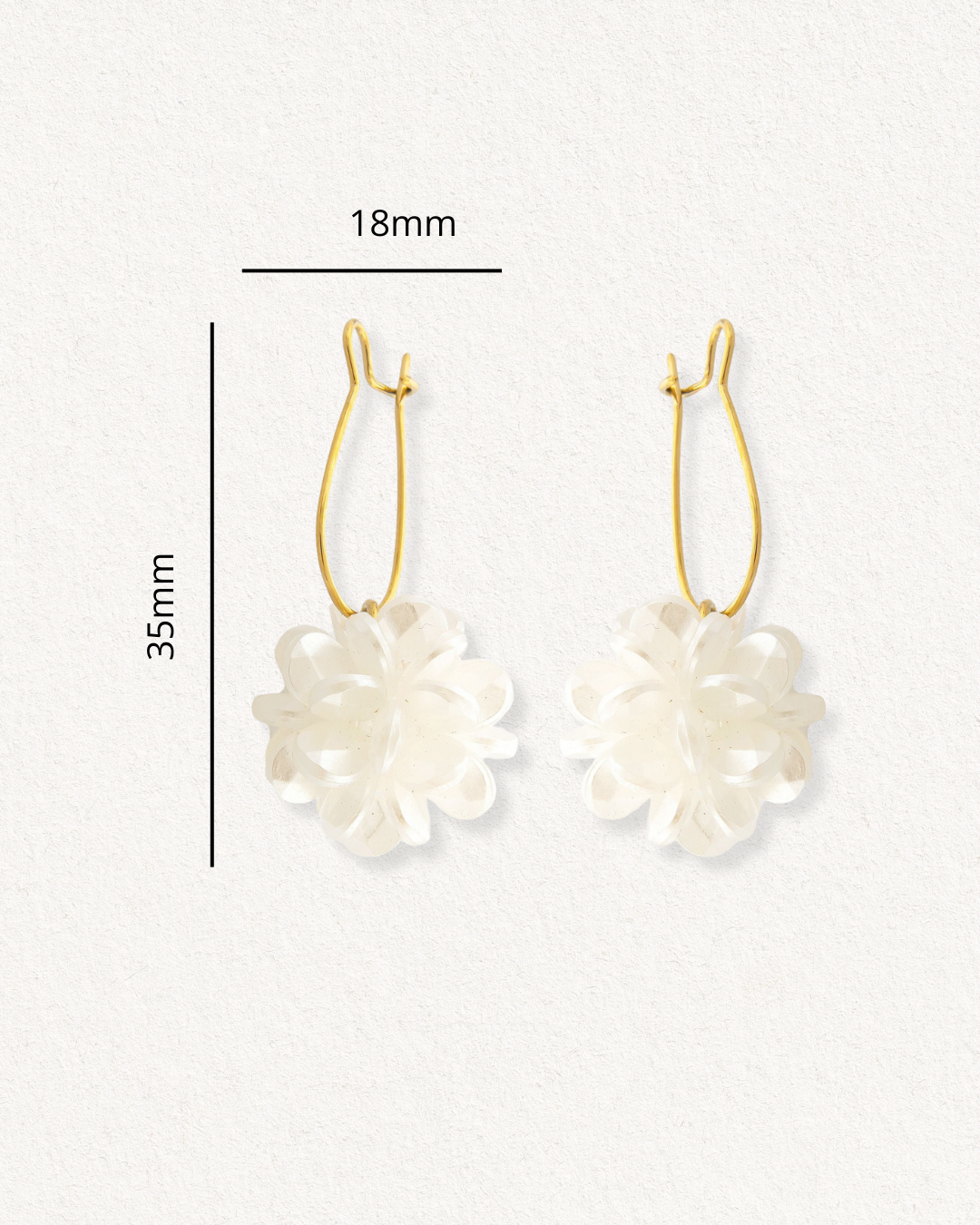 Auskari - Rītausma by Como Jewelry: zelta riņķveida auskari ar baltiem ziedu piekariņiem uz gaiša fona. Izmērs: 35 mm augstums, 18 mm platums. Moderni auskari ikdienai, lieliski piemēroti jebkura tērpa paspilgtināšanai.