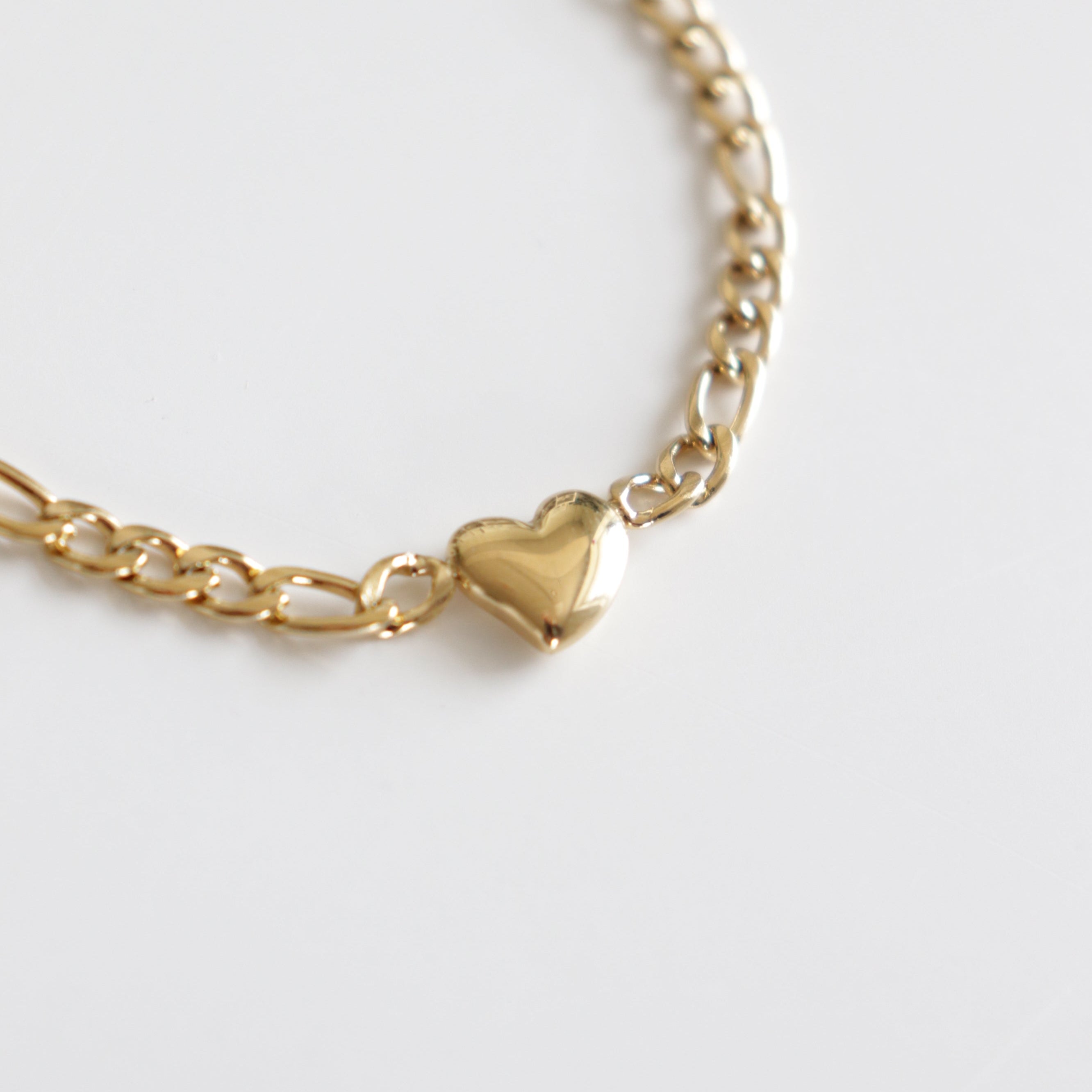 Kaklarota - Sirds tuvplāns no Como Jewelry, ar nelielu, spīdīgu sirds formas piekariņu centrā, kas attēlots uz balta fona.