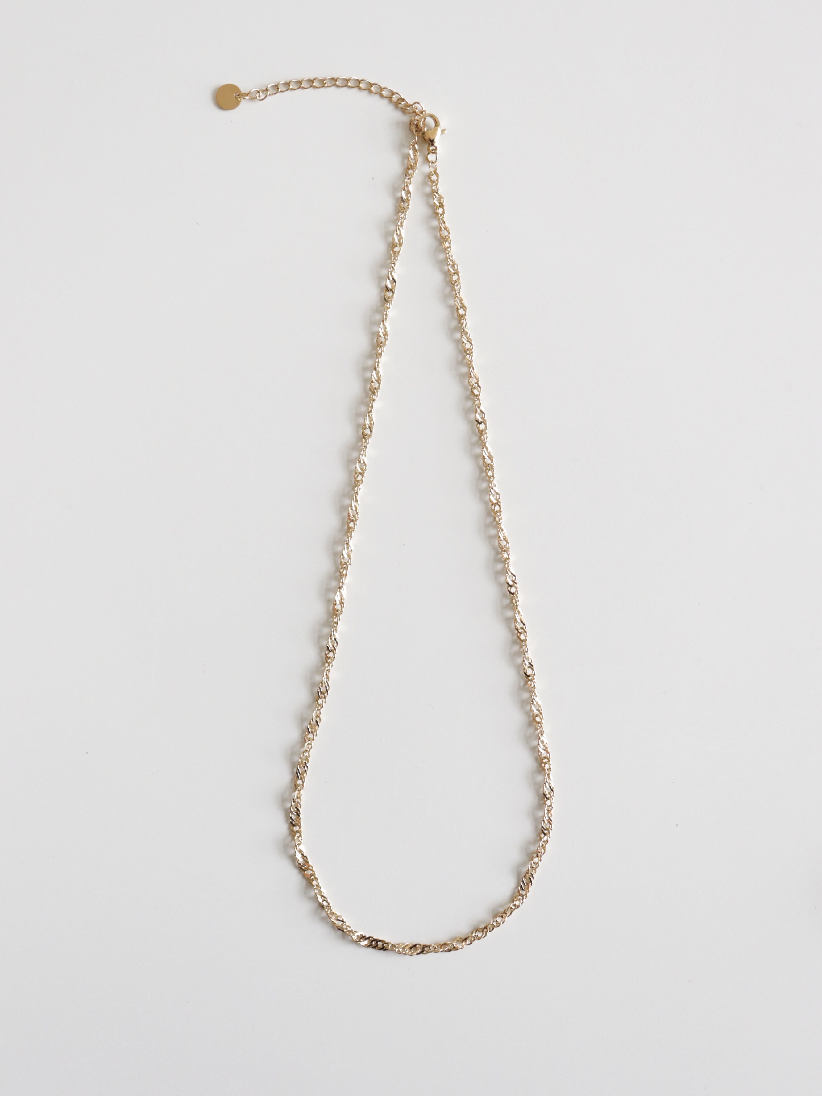 Kaklarota - Zelta vijums no Como Jewelry ir zelta virves ķēdītes kaklarota ar mazu apaļu piekariņu pie regulējamas aizdares, kas attēlota uz balta fona.