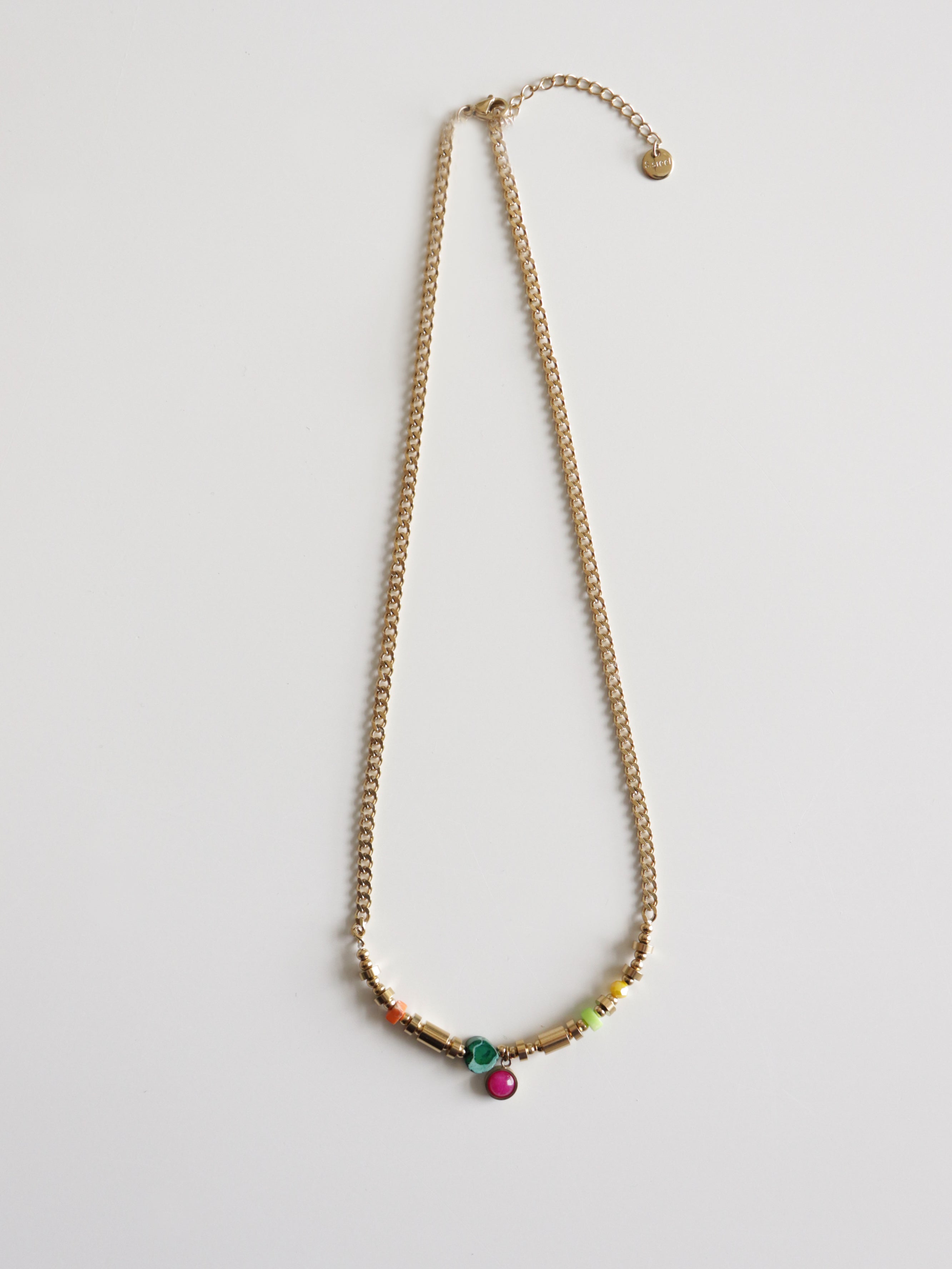 Como Jewelry Kaklarota - Rio: mūsdienīga juveliertērauda kaklarota ar zaļiem, tirkīza un rozā krellīšu akcentiem centrā, izkārtota uz vienkārša balta fona.