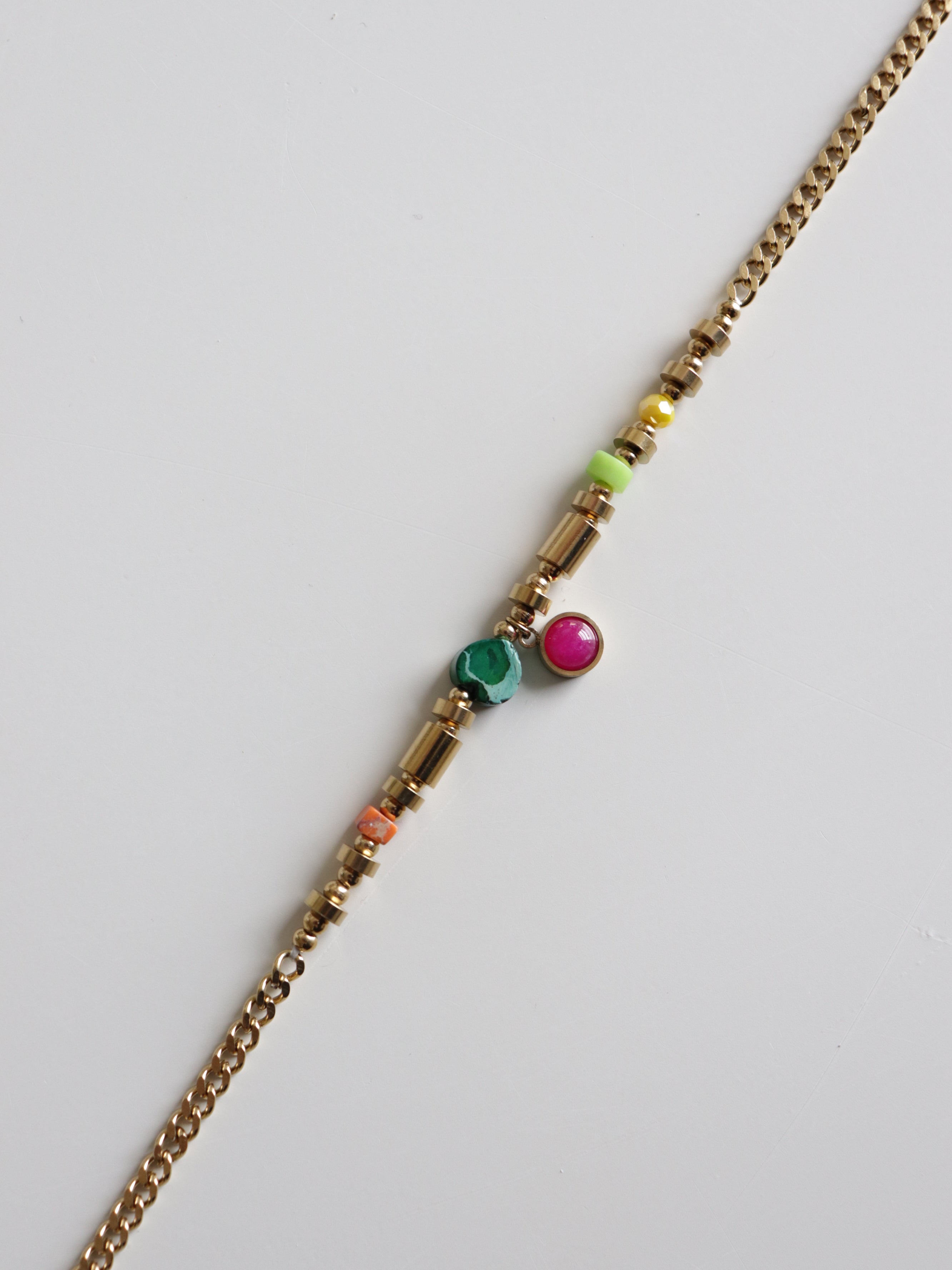 Mūsdienīga dizaina "Kaklarota - Rio" no Como Jewelry: juveliertērauda kaklarota ar zelta ķēdīti, rotāta krāsainiem cilindriskiem un apaļiem krellīšu akcentiem - zaļā, rozā, dzeltenā un oranžā tonī.