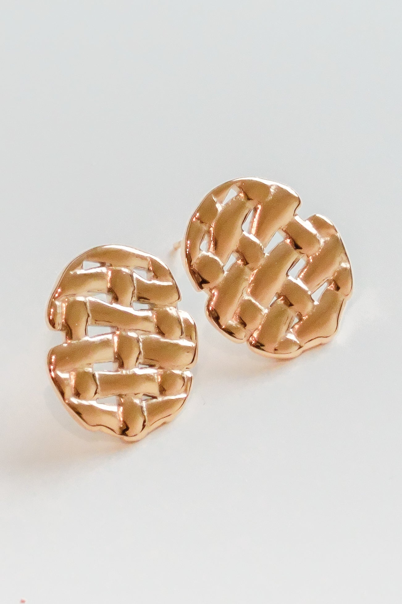 Mazie auskari - Pinums by Como Jewelry: apaļi, zelta krāsas auskari ar fakturētu austu rakstu uz balta fona.